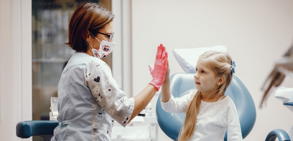 Cute little girl sitting in the dentist's office